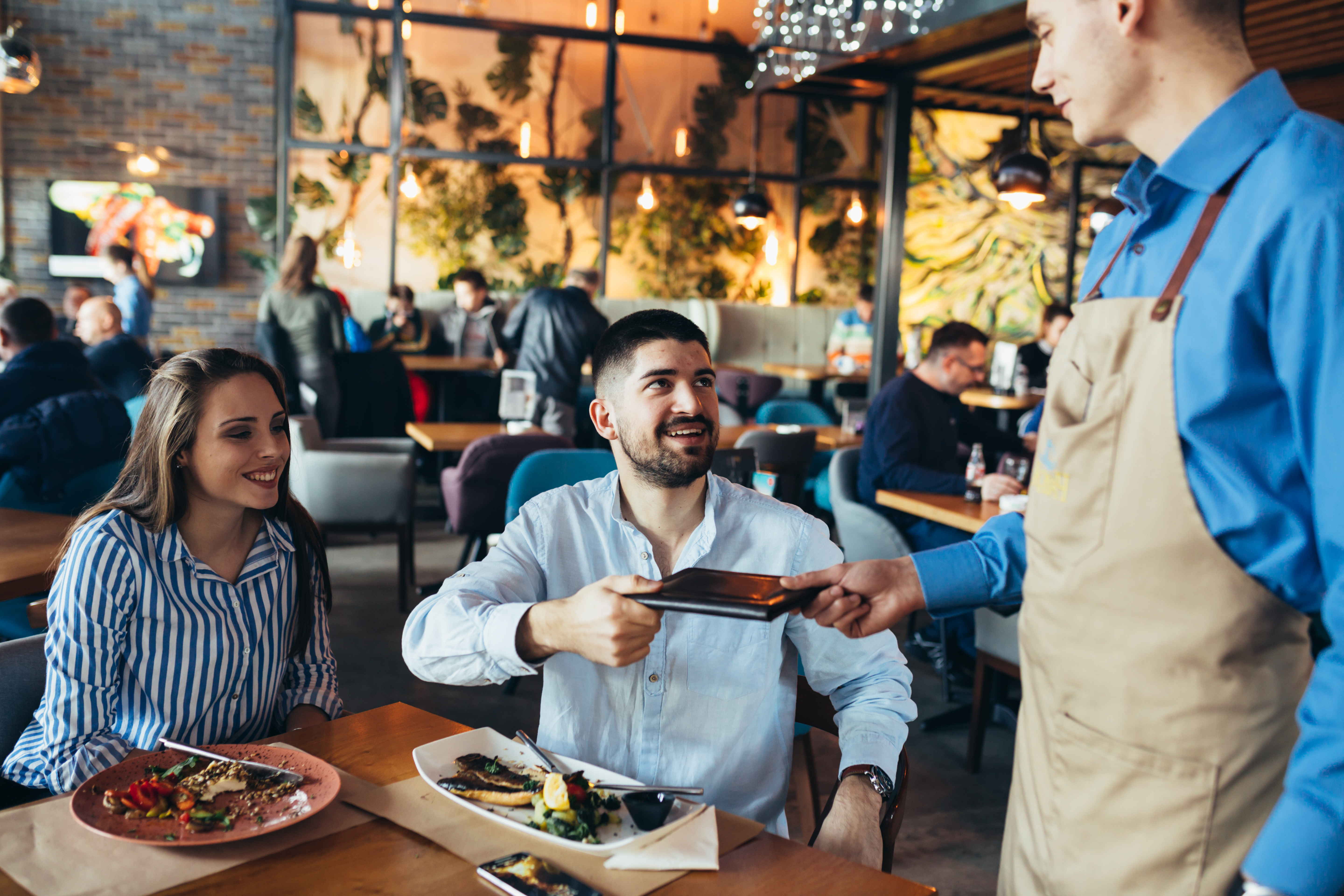 Restaurant Server Handing Customer Receipt 