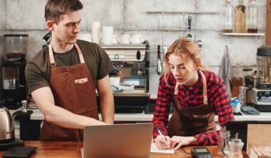 Two Restaurant Workers Using Predictive Scheduling Software