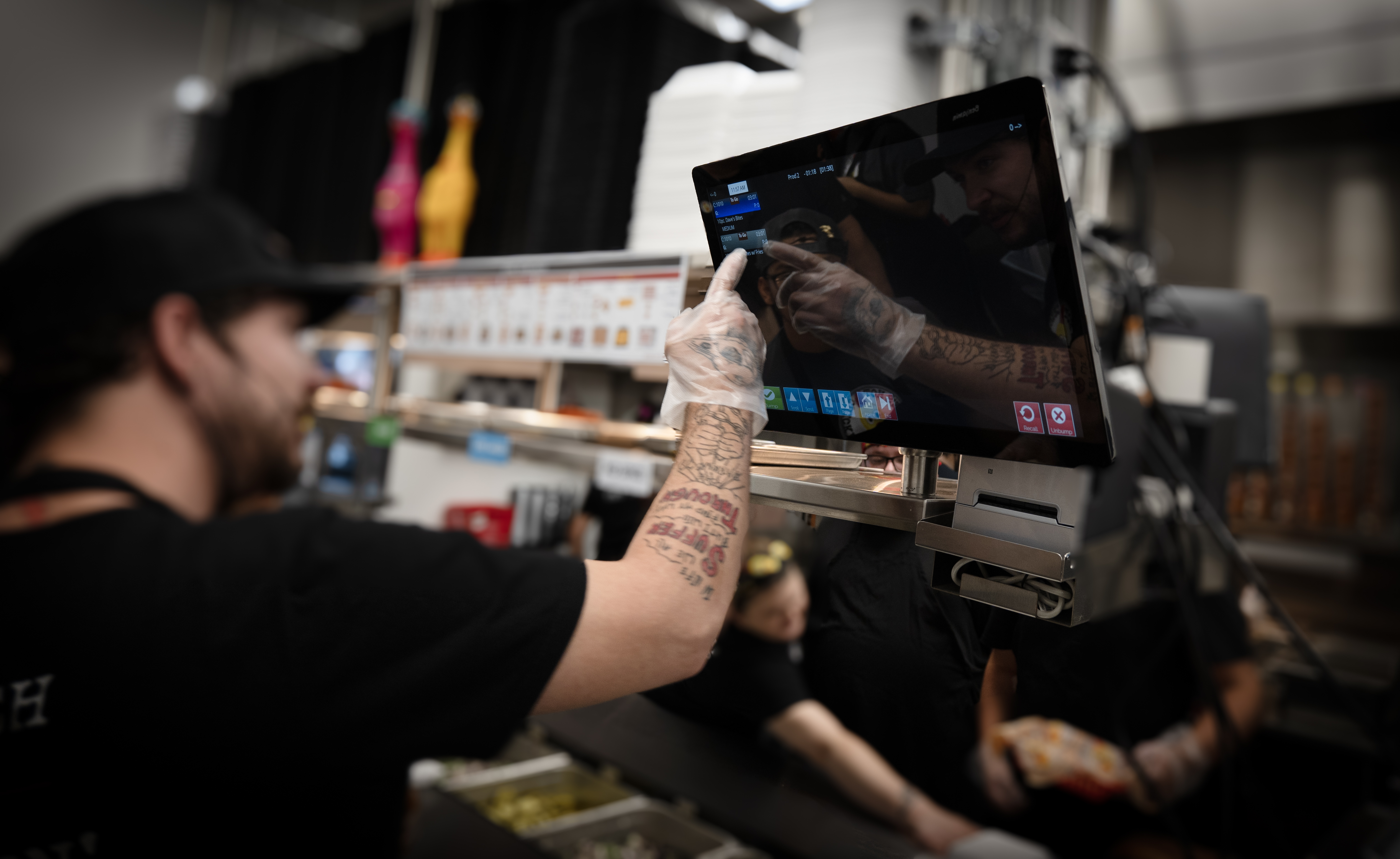 An employee using a kitchen display system.