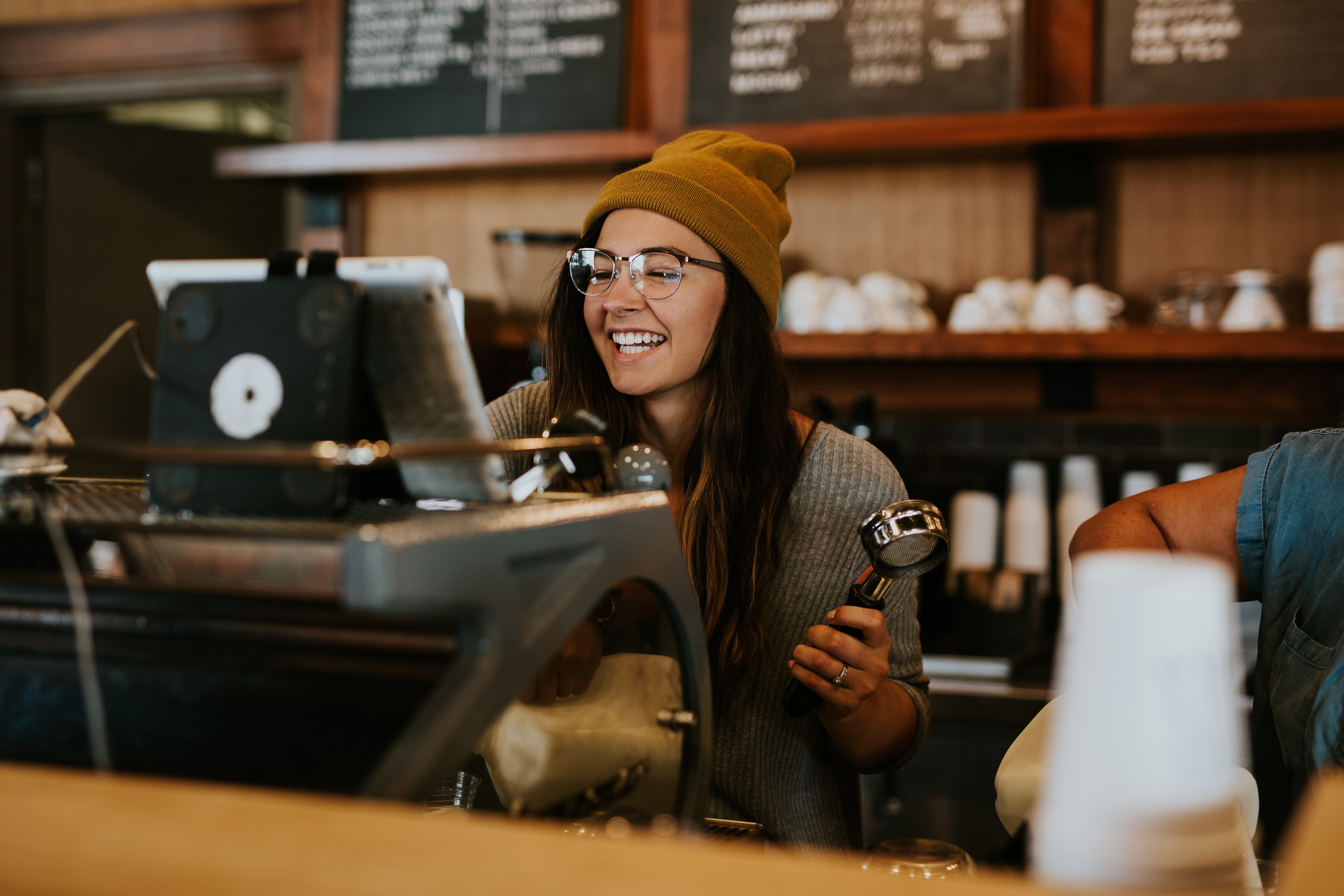 Barista working at a coffee shop using restaurant management software